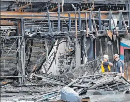  ?? Chris O’meara The Associated Press ?? Two workers inspect the damage to a sporting goods store Monday in Tampa, Fla., after the establishm­ent was looted and burned during a demonstrat­ion Saturday night.