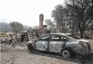  ?? Yalonda M. James / The Chronicle ?? Charred vehicles rest in a driveway at a burned home off of English Hills Road in Vacaville on Wednesday.