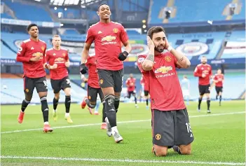  ??  ?? Bruno Fernandes (right) celebrates with teammates after scoring the opening goal from the penalty spot during football match between Manchester City and Manchester United on Sunday. - AFP photo