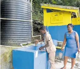  ?? ?? Principal Francine Taylor Arnett watches as a student washes his hands after using the toilet facilities.