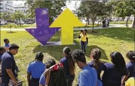  ?? PHOTOS BY WILFREDO LEE / AP 2016 ?? Tour guide Lorraine Kutner talks to a group of children next to a sculpture titled: “Arrow Sculpture” by artist Tony Tasset, being displayed in front of the Bass Museum of Art last year in Miami Beach. Art Basel Miami Beach has agreed to stage the...