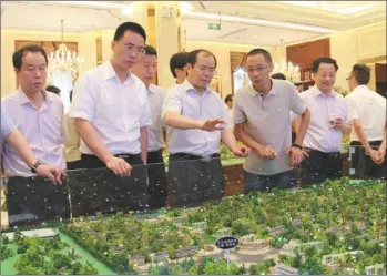  ??  ?? Tan Xiaoping (third from left), Party chief of Wangcheng district, inspects a planning design.