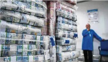  ??  ?? Stacks of money: A Bank Mandiri employee stands near stacks of rupiah banknotes waiting to be delivered to branches, at the bank’s headquarte­rs in Jakarta. Many thought the falling rupiah could spark off a stock market sell-off but the panic button was not pushed for several reasons. — Reuters