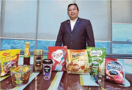  ?? (Foto Khairul Azhar Ahmad/bh) ?? Othman bersama produk yang dikeluarka­n Nestle (Malaysia) Sdn Bhd.