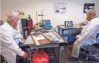  ?? PHOTOS BY AMANDA MORRIS/THE REPUBLIC ?? Botanisol Analytics employees Wesley Brookover, right, and James Foley, left, work on developing a prototype for the company’s spectromet­er machine.