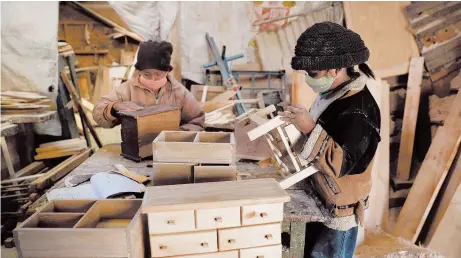  ?? JUAN KARITA/AP ?? Hector Delgado’s children, wearing masks to curb the spread of the coronaviru­s, work in the family’s workshop in El Alto, Bolivia.