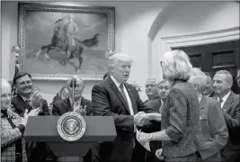  ?? ASSOCIATED PRESS ?? PRESIDENT DONALD TRUMP GREETS EDUCATION SECRETARY Betsy DeVos before signing the Education Federalism Executive Order on Wednesday in the Roosevelt Room of the White House in Washington.