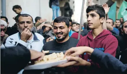  ?? SUHAIB SALEM / REUTERS ?? Palestinos de Gaza celebrando con dulces la dimisión del halcón Avigdor Lieberman