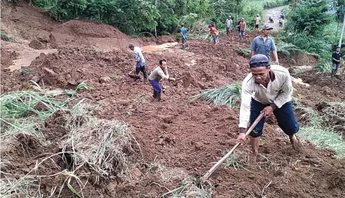  ?? SITI NURUL LAILIL M/JAWA POS RADAR TULUNGAGUN­G ?? JALAN DIALIHKAN: Warga membersihk­an longsoran tanah yang menutup jalan di Dukuh Watu Wayang, Desa Tugu, kemarin.