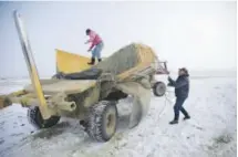  ??  ?? Rancher Jerry Miller, 79, and his daughter Tina Steeves deliver hay to his cattle on his ranch in Crane, Ore. Behind the standoff between ranchers and the U.S. government in Oregon is a decades-old idea in the West to take back control of federal lands.