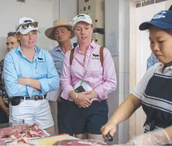  ?? Pictures: Contribute­d ?? INSIGHT: Four Daughters Premium Black Angus’ Molly (left) and Bonnie Penfold inspect Vietnamese butcher Meatworks Asia.