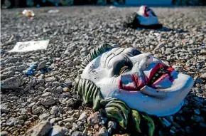  ?? AP ?? Halloween masks litter the ground amongst signs of chaos at the scene of a deadly shooting in Greenville, Texas.