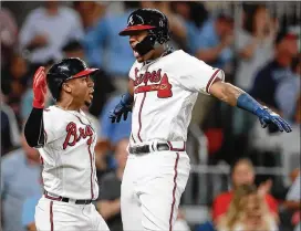  ?? CURTIS COMPTON / CCOMPTON@AJC.COM ?? Braves outfielder Ronald Acuna (right) and second baseman Ozzie Albies celebrate after Acuna hit a three-run homer, his second home run of the night, against the Marlins in August.