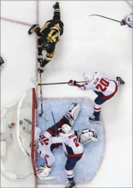  ?? GENE J. PUSKAR — THE ASSOCIATED PRESS ?? Pittsburgh’s Evgeni Malkin (71) dives to poke a loose puck past Washington’s goaltender Braden Holtby (70) during the second period in Game 4 in Pittsburgh Thursday. The Penguins won 3-1.