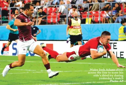  ??  ?? Wales Josh Adams dives across the line to score his side’s third try during yesterday’s match Photo: AP Jerome Pugmire AP Sports Writer