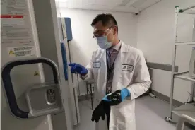  ?? Photograph: Mark Lennihan/AP ?? Pharmacist Billy Sin by a fridge that will store Covid-19 vaccines at Mount Sinai Queens hospital in New York. Pfizer-BioNTech’s vaccine presents challenges because it must be stored at -94F (-70C).