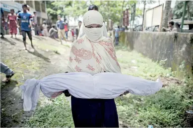  ??  ?? A Bangladesh­i woman holds the body of a Rohingya Muslim refugee at a school near Inani beach in Cox's Bazar district on September 29, 2017. AFP / Fred Dufour