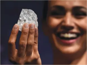  ??  ?? A MODEL shows off the 1,109-carat ‘Lesedi La Rona,’ the largest gem-quality rough diamond discovered in more than 100 years, during a sale preview at Sotheby’s auction house in London last year.