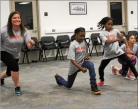  ?? MICHILEA PATTERSON — DIGITAL FIRST MEDIA ?? Kelly Skokowski of the YWCA Tri-County Area, far left, does lunges alongside young girls during a health and wellness summit at the Montgomery County Community College campus in Pottstown.