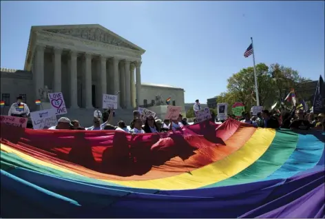  ?? AP PHOTO/JOSE LUIS MAGANA ?? In this 2015 file photo, demonstrat­ors stand in front of a rainbow flag of the Supreme Court in Washington.