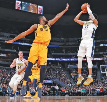  ?? AP ?? Utah Jazz’s Derrick Favors ( left) in action in their NBA match against Denver Nuggets in Denver on Tuesday. Nuggets won 107- 83.