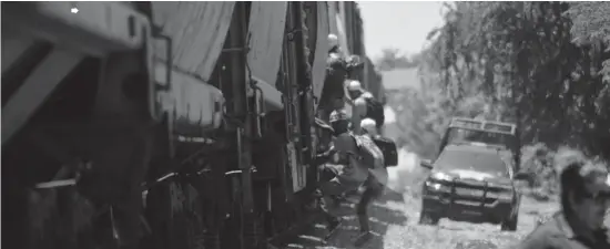  ?? FOTO VICTOR HUGO OLIVAS ?? > Migrantes intentan subir al tren, a su paso por un poblado cerca de Mazatlán, Sinaloa.