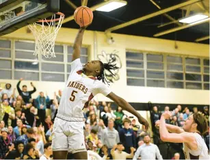  ?? HARTFORD COURANT ?? Windsor Locks’ Malike Alassani dunks the ball on the final possession in his team’s win against Portland in a Boys Division V semifinal at East Hartford High School on Wednesday.