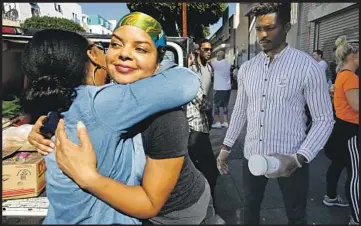  ?? By Benjamin Oreskes ?? TIFFANY ROSE, the founder of My Friend’s House Foundation, receives a hug from a fellow volunteer.