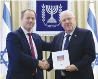  ??  ?? PRESIDENT REUVEN RIVLIN receives the 2016 democracy index from Yohanan Plesner yesterday in Jerusalem.