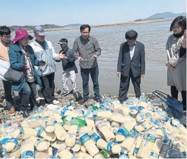  ?? ANNA FIFIELD PHOTOS/THE WASHINGTON POST ?? These bottles carry rice, worm medicine and USB sticks with videos and songs along the Han River to North Korea.