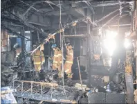  ?? AP PHOTO ?? Firefighte­rs inspect a burnt hospital after a fire in Miryang, South Korea, Friday. The fire killed 37 and injured dozens.