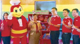  ??  ?? Jollibee Group Foundation’s “Jolli-Istante” program donates a shelf full of educationa­l books to Pawing Elementary School: Jollibee Tacloban franchise owner Irene Chan, Pawing Elementary School principal Loreta Gulariza, Jollibee president Joseph...