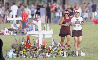  ?? MIKE STOCKER/ AP ?? Runners pass a memorial for the victims of the Feb. 14 Marjory Stoneman Douglas High School shooting, at Pine Trails Park in Parkland, Fla., on Wednesday.