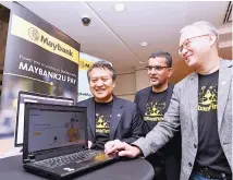  ??  ?? Photo shows Maybank’s group chief strategy officer Maybank Micheal Foong (right) with group chief technology officer Mohd Suhail Amar Suresh (middle) and group chief financial officer Maybank Datuk Amirul Feisal Wan Zahir looking websites on a digital...