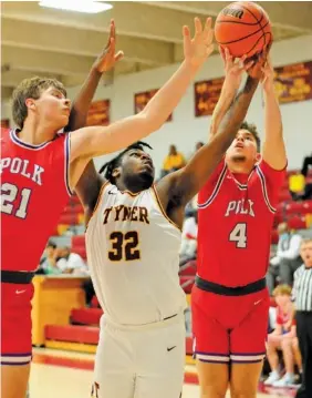  ?? STAFF PHOTO BY ROBIN RUDD ?? Polk County’s Alex Armstrong (21) and Noah Shaw (4) battle for a rebound with Tyner’s Anthony Sims (32) on Tuesday.