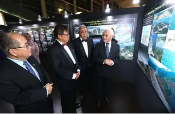  ??  ?? Taib (right) visits a gallery showcasing the transforma­tion of SCORE over the last 10 years together with Abang Johari (second left), Uggah (left) and Awang Tengah (third left) prior to the start of the dinner.