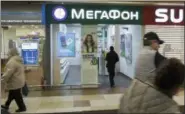  ?? IVAN SEKRETAREV — ASSOCIATED PRESS ?? People walk past a Megafon mobile phones shop in Moscow, Russia, on Saturday. A top Russian mobile operator said Friday it had come under cyberattac­ks that appeared similar to those that crippled some hospitals in Great Britain.