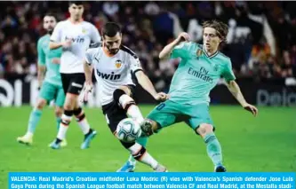  ?? — AFP ?? VALENCIA: Real Madrid’s Croatian midfielder Luka Modric (R) vies with Valencia’s Spanish defender Jose Luis Gaya Pena during the Spanish League football match between Valencia CF and Real Madrid, at the Mestalla stadium in Valencia.