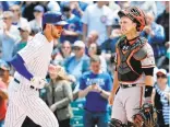  ?? JON DURR/GETTY IMAGES ?? Buster Posey reacts as Kris Bryant of Cubs heads to the dugout after hitting a home run in the first inning Thursday.