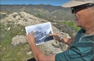  ?? Signal file photo ?? Community Hiking Club Executive Director Dianne Erskine-Hellrigel points to the place she is standing on top of the dam in an 87-year-old photo taken shortly after after the dam broke in March 1928.