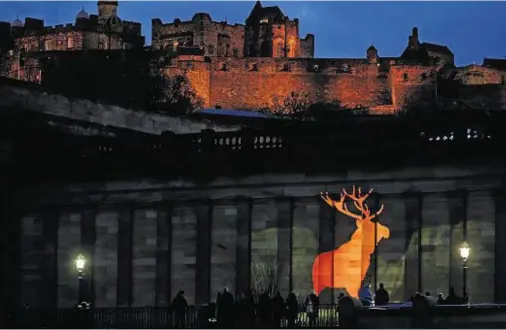  ??  ?? ICON: An animation of a stag is projected on to National Galleries of Scotland building to highlight its bid to buy The Monarch of the Glen