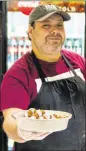  ??  ?? Samer Tammour offers a plate of the Veggie Feast, which includes hummus, baba ganoush, tabbouleh salad, fattoush salad and five falafels.