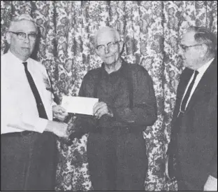  ?? EL File Photo ?? Lester Bertke, center, recent retiree at Stamco, receives his first retirement check from Corporate Vice President L.D. Harmony, right, and Plant Superinten­dent, F.L. Luedeke, left. Harmony and Luedeke also expressed their appreciati­on for his years of loyal and dependable service to Bertke for many years of continued good health and happiness. Les responded that he was looking forward to warmer weather and sunshine, catching up on the work around the house and doing some fishing. He was employed at Stamco since April 15, 1957.