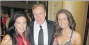  ??  ?? Global Calgary’s Graham Stone is flanked by beauties Nadine Shenher, left, and Maria Plesa.