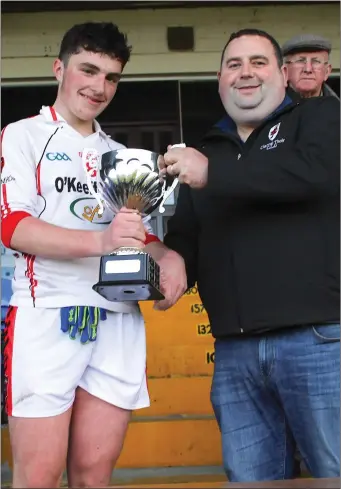  ??  ?? Sean O’Keeffe East Kerry Coiste nanOg presenting the East Kerry Division 1 Cup to Rathmore winning captain Darragh Rahilly after his side defeated Legion in the East Kerry U16 division 1 Championsh­ip final at Fitzgerald Stadium, Killarney.