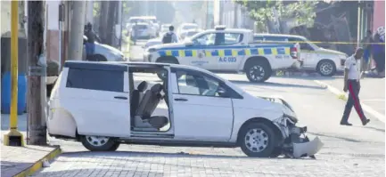  ?? (Photo: Naphtali Junior) ?? The seven-seater vehicle, which the police say the gunmen were travelling in, abandoned at the intersecti­on of King and Charles streets.