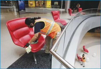  ?? ASSOCIATED PRESS ?? Cleaning crew members Rosalinda Venado (top) cleans and disinfects the center throughout the day Friday, and after-hours, with a focus on high-touch, high-traffic surfaces while using a strong disinfecta­nt at the Beverly Center shopping mall.