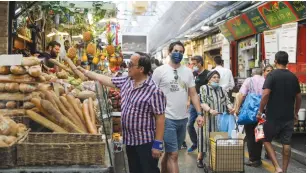  ??  ?? A SHOPPER buys bread at a stall in Mahaneh Yehudah earlier this month. (Marc Israel Sellem/The Jerusalem Post)