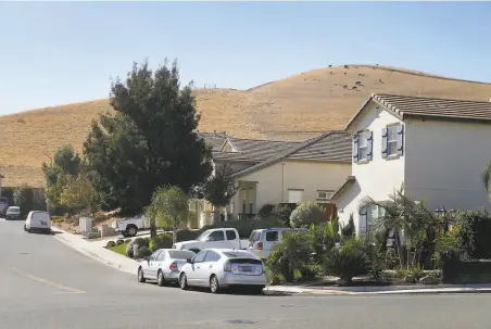  ?? Photos by Paul Chinn / The Chronicle ?? Cattle graze on a hillside above homes and adjacent to a proposed residentia­l developmen­t in the hills near Pittsburg. A plan to add 1,500 homes on more than 600 acres adjacent to the San Marco community is opposed by several environmen­tal groups.