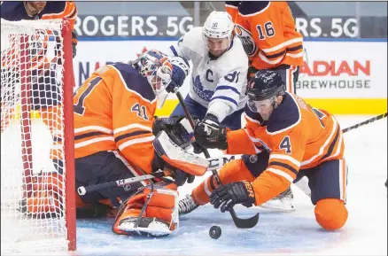  ??  ?? Edmonton Oilers goalie Mike Smith (41) makes a save as Oilers’ Kris Russell (4) and Toronto Maple Leafs’ John Tavares (91) go for the rebound during the third period of an NHL hockey game, on March 3, in Edmonton, Alberta. (AP)